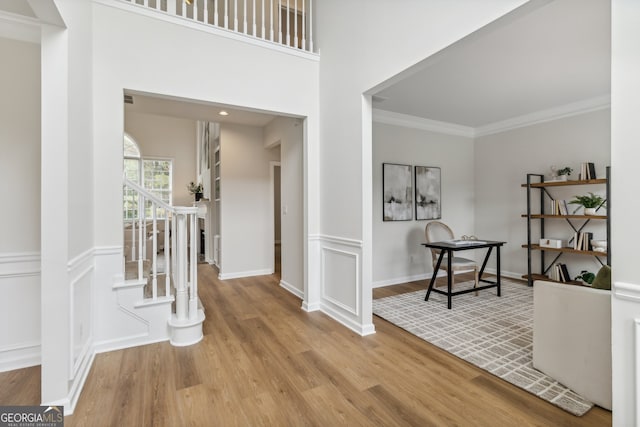 entrance foyer featuring light hardwood / wood-style flooring and crown molding