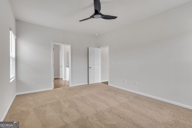 unfurnished bedroom featuring ceiling fan, light carpet, and multiple windows