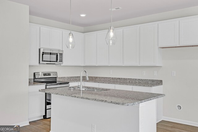 kitchen featuring decorative light fixtures, sink, white cabinetry, and stainless steel appliances