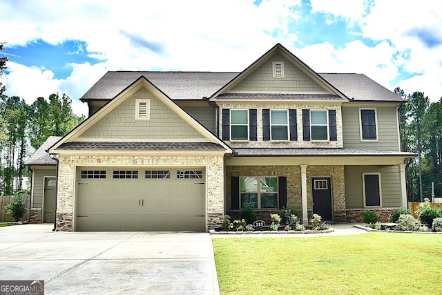 craftsman house featuring a front yard and a garage