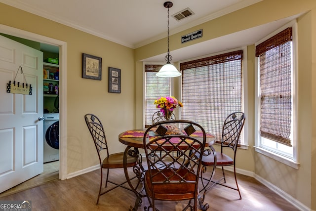 dining area with washer / clothes dryer, hardwood / wood-style flooring, and crown molding