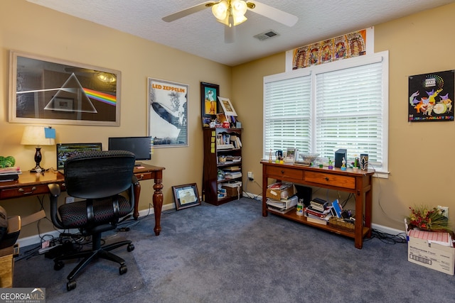 carpeted home office with a textured ceiling and ceiling fan