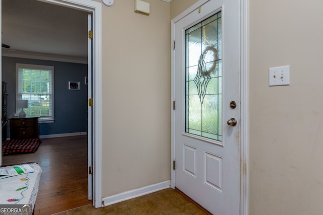 entryway with ornamental molding and dark hardwood / wood-style floors