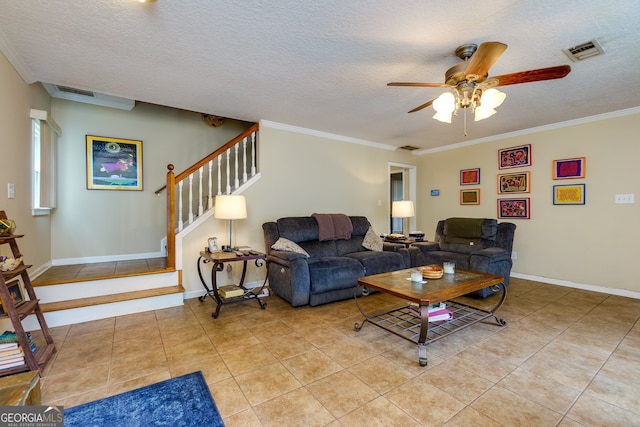 tiled living room featuring ceiling fan, a textured ceiling, and crown molding