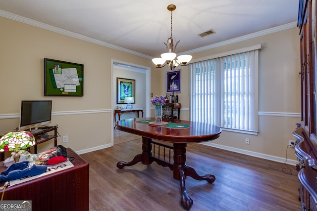 dining room featuring crown molding, an inviting chandelier, and hardwood / wood-style flooring