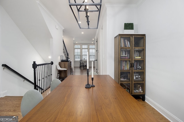 dining room with wood-type flooring, a notable chandelier, and ornamental molding