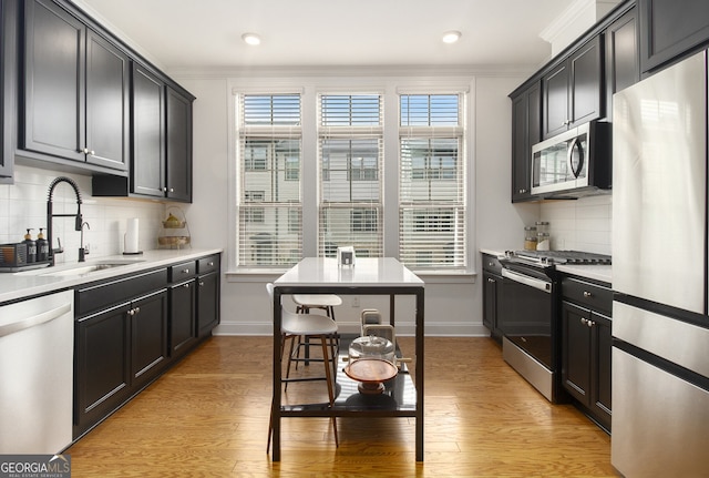 kitchen featuring sink, backsplash, plenty of natural light, appliances with stainless steel finishes, and ornamental molding