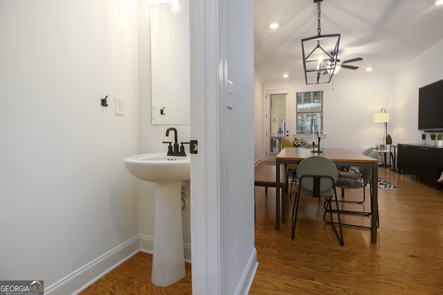 bathroom with ceiling fan, sink, wood-type flooring, and ornamental molding