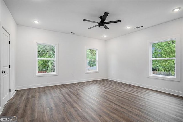 spare room with ceiling fan, dark wood-type flooring, and a healthy amount of sunlight