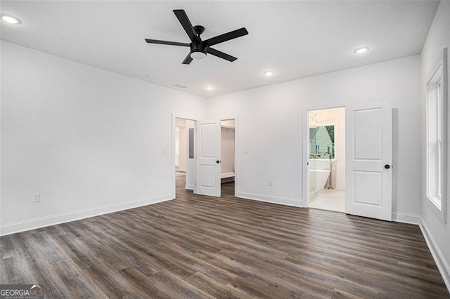 unfurnished bedroom with dark wood-type flooring, ensuite bath, and ceiling fan