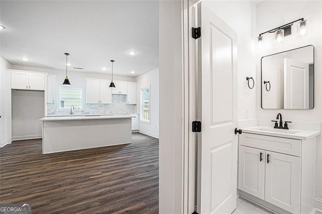 interior space with wood-type flooring, tasteful backsplash, and vanity