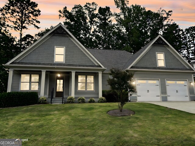 craftsman house with a garage, a front lawn, and a porch