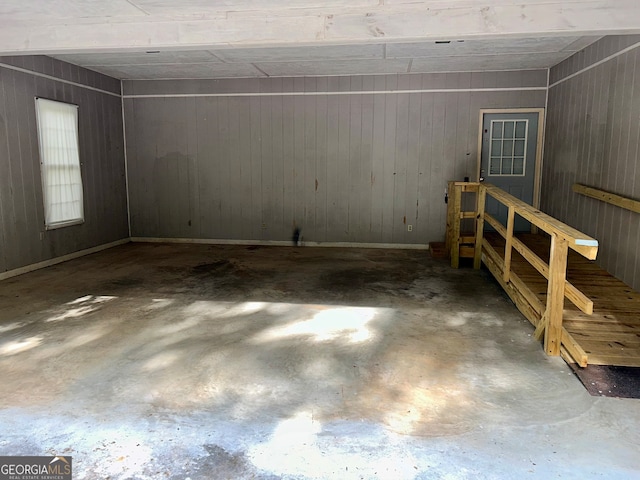 interior space featuring wood walls and concrete floors