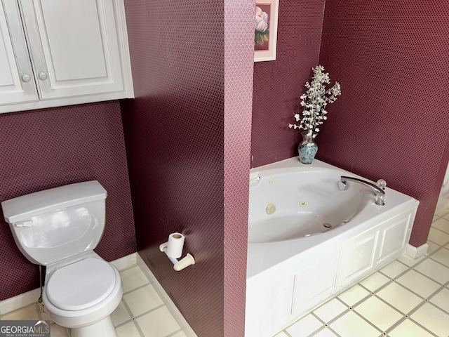 bathroom featuring tile patterned floors, a tub, and toilet