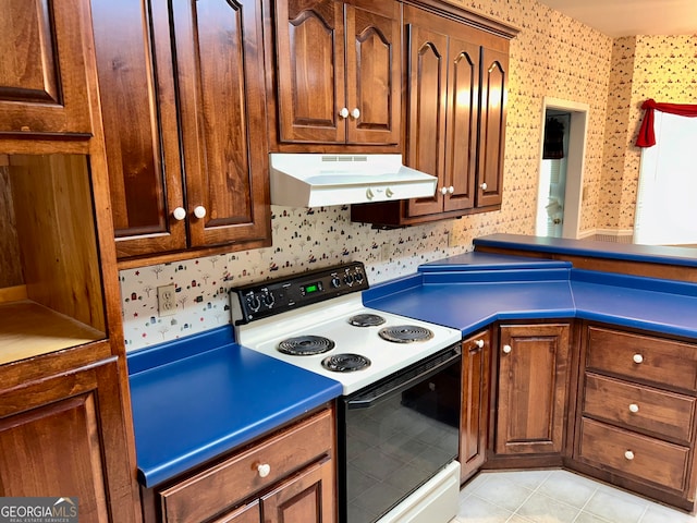 kitchen featuring electric stove and light tile patterned flooring