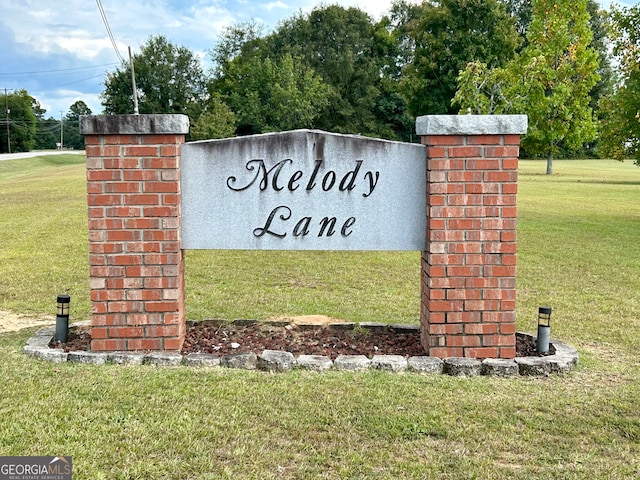 community / neighborhood sign featuring a yard