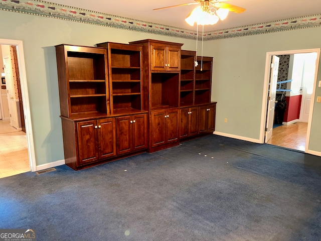 unfurnished living room with dark colored carpet and ceiling fan