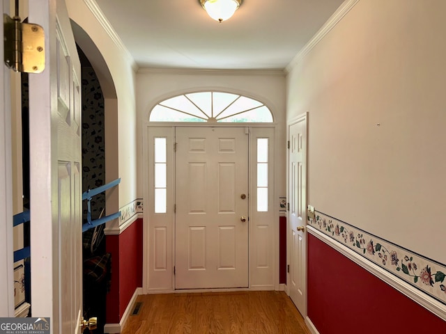 foyer with crown molding and hardwood / wood-style floors