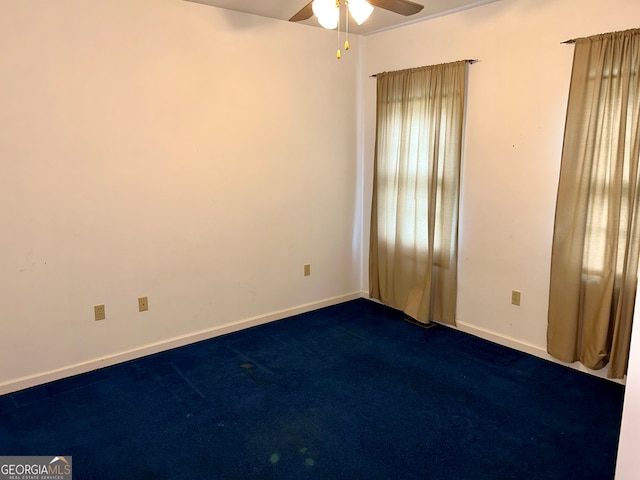 carpeted empty room with ceiling fan and a wealth of natural light