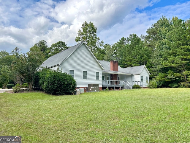 view of home's exterior featuring a lawn, a wooden deck, and cooling unit