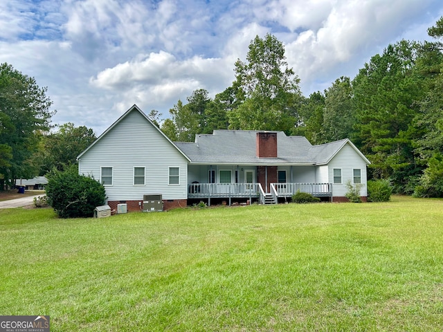 view of front of house with a wooden deck and a front yard