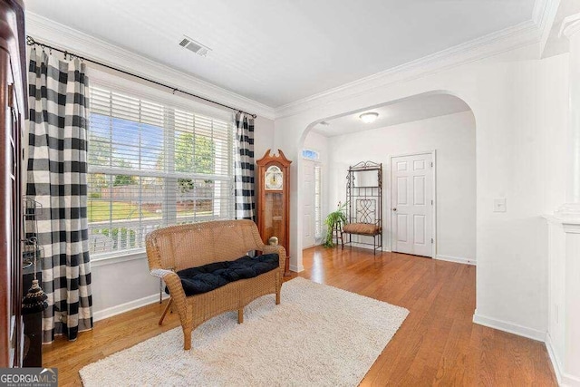 sitting room with light hardwood / wood-style flooring and ornamental molding