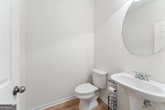 bathroom featuring hardwood / wood-style flooring, toilet, and sink