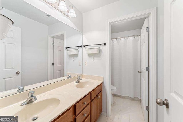 bathroom with tile patterned flooring, vanity, and toilet