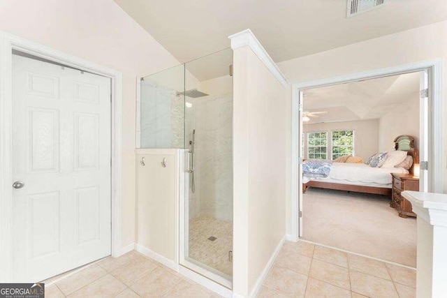 bathroom with tile patterned flooring, a shower with door, and ceiling fan