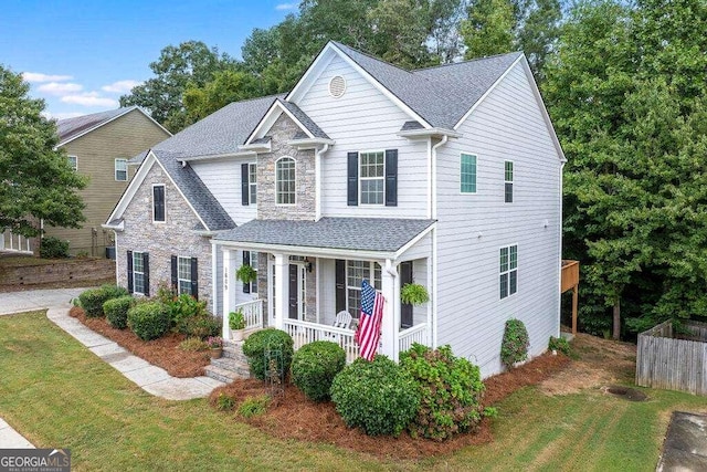 view of property with a porch and a front lawn