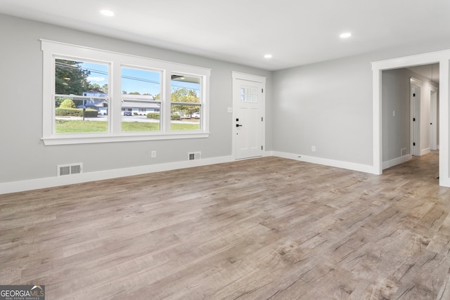 kitchen featuring wall chimney exhaust hood, stainless steel appliances, hanging light fixtures, and plenty of natural light