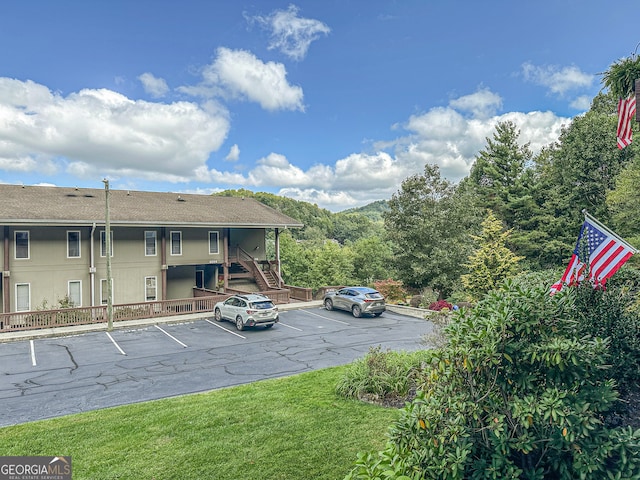 view of parking / parking lot featuring a lawn