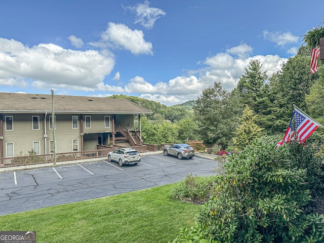 view of parking / parking lot featuring a lawn