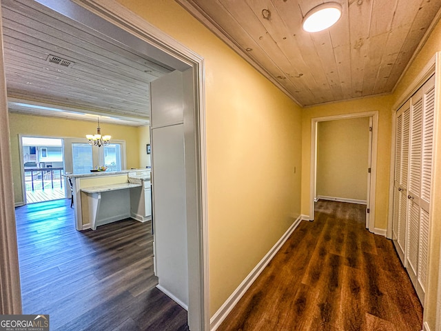 corridor with a notable chandelier, wood ceiling, and dark hardwood / wood-style flooring