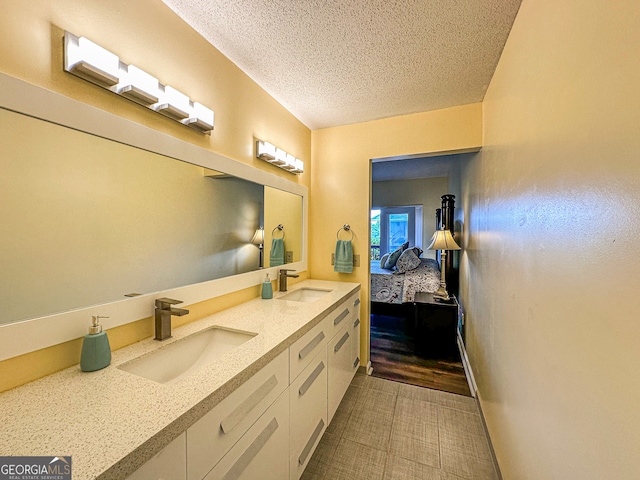 bathroom with a textured ceiling, hardwood / wood-style flooring, and vanity