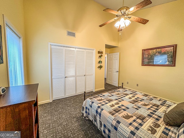 bedroom featuring ceiling fan, dark colored carpet, high vaulted ceiling, and a closet