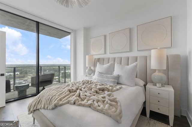 bedroom with access to outside, light hardwood / wood-style flooring, and a wall of windows