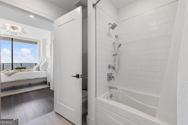 bathroom featuring hardwood / wood-style flooring, toilet, and shower / bathtub combination with curtain