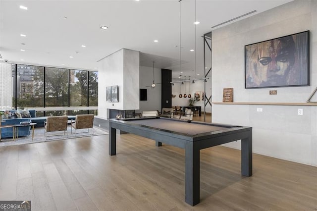 game room with billiards, a wall of windows, and light wood-type flooring