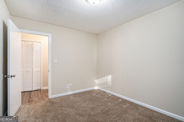 carpeted spare room with a textured ceiling