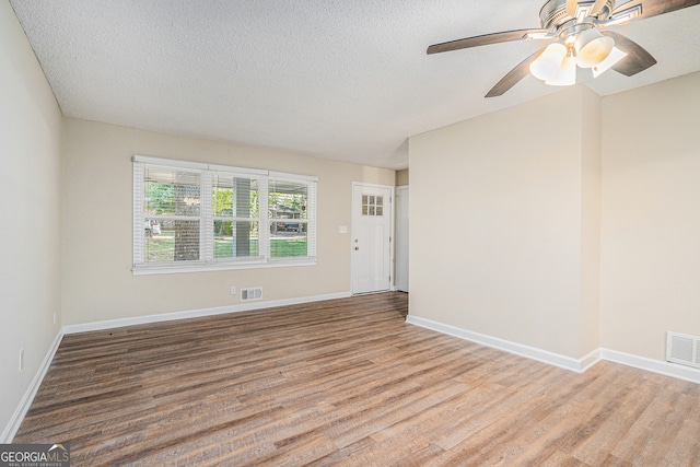 unfurnished room featuring ceiling fan, a textured ceiling, and light wood-type flooring