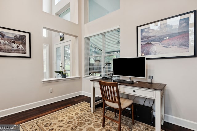 office with a high ceiling and dark hardwood / wood-style flooring