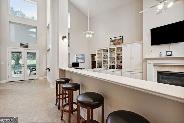 kitchen featuring high vaulted ceiling, white cabinets, ceiling fan, and a healthy amount of sunlight