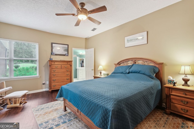 bedroom with a textured ceiling, ceiling fan, and dark hardwood / wood-style flooring