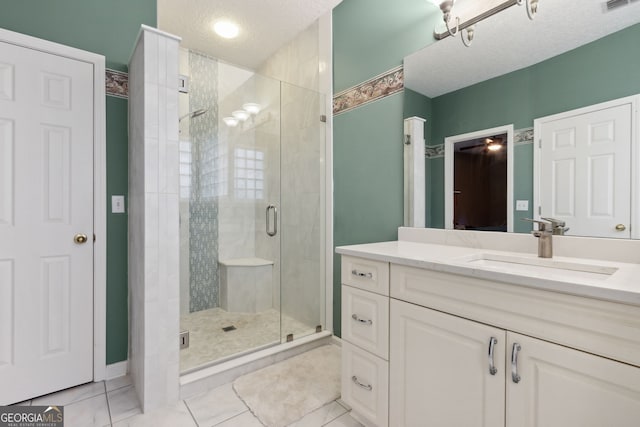 bathroom with vanity, a textured ceiling, and a shower with shower door