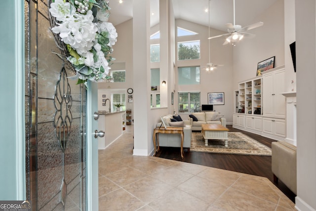 interior space featuring ceiling fan, light hardwood / wood-style floors, and high vaulted ceiling