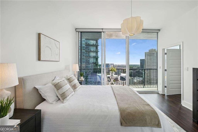 bedroom with access to outside, floor to ceiling windows, and dark wood-type flooring