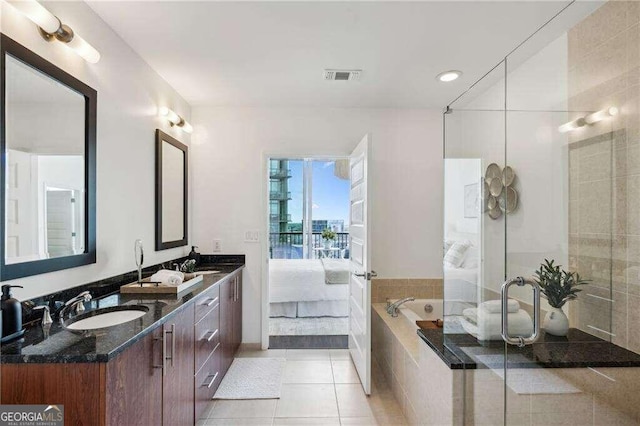 bathroom featuring vanity, tile patterned floors, and a relaxing tiled tub