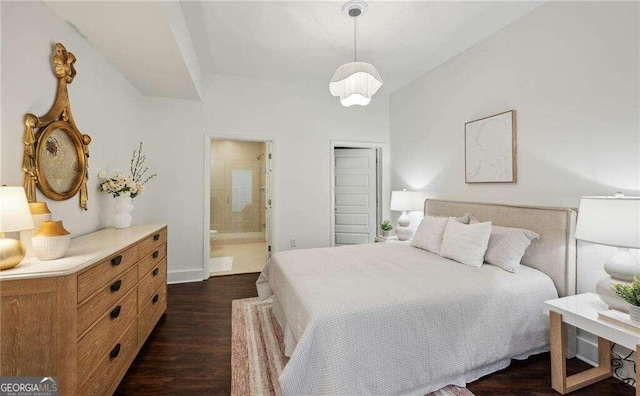 bedroom with ensuite bathroom and dark wood-type flooring