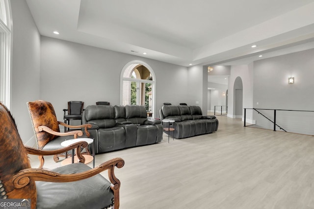 living room featuring a raised ceiling and light hardwood / wood-style floors